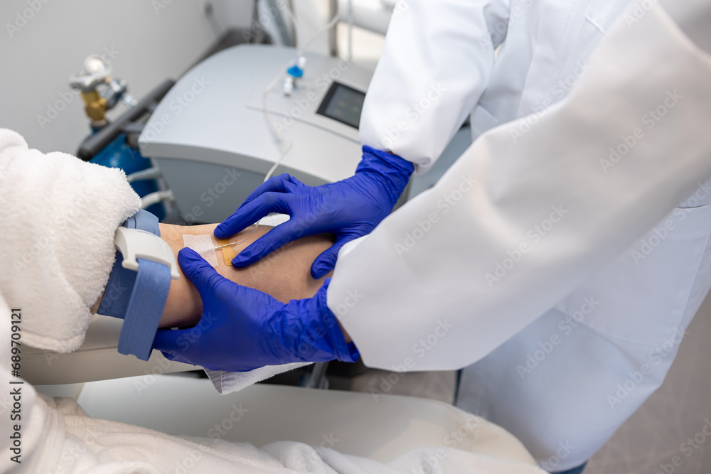 Woman receiving vitamin IV infusion drip in wellness center or beauty salon. Woman receiving vitamin IV infusion drip in wellness center or beauty salon.