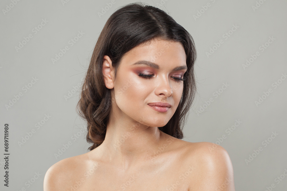 healthy fenale model with clear fresh skin. Brunette woman with dark hair on blue background healthy fenale model with clear fresh skin. Brunette woman with dark hair on blue background