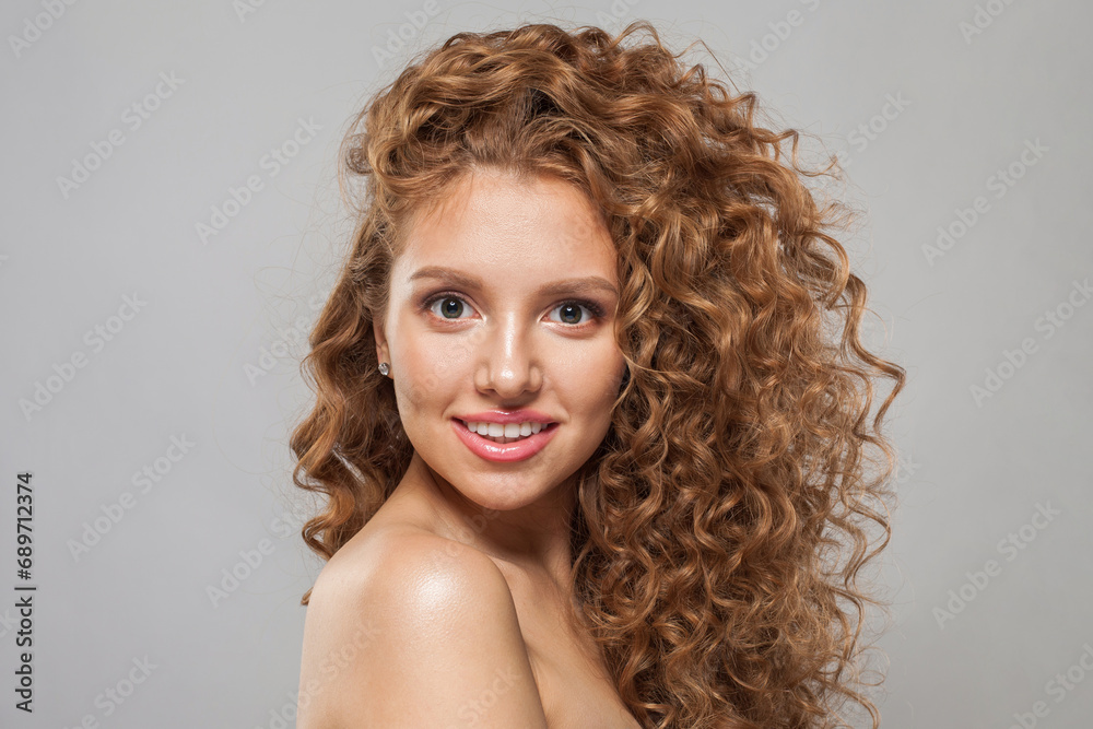 Smiling redhead woman fashion model with shiny curly brown hair and natural healthy fresh skin on white background. Cosmetology, haircare and beauty treatment concept Smiling redhead woman fashion model with shiny curly brown hair and natural healthy fresh skin on white background. Cosmetology, haircare and beauty treatment concept