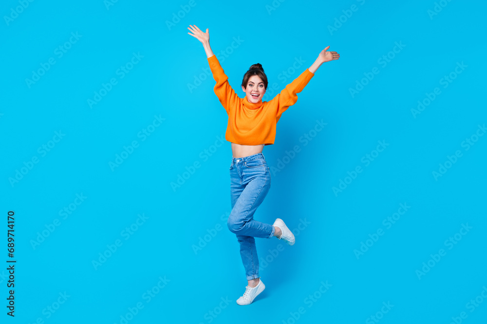 Full length photo of impressed funky lady wear knitted pullover rising arms having fun isolated blue color background