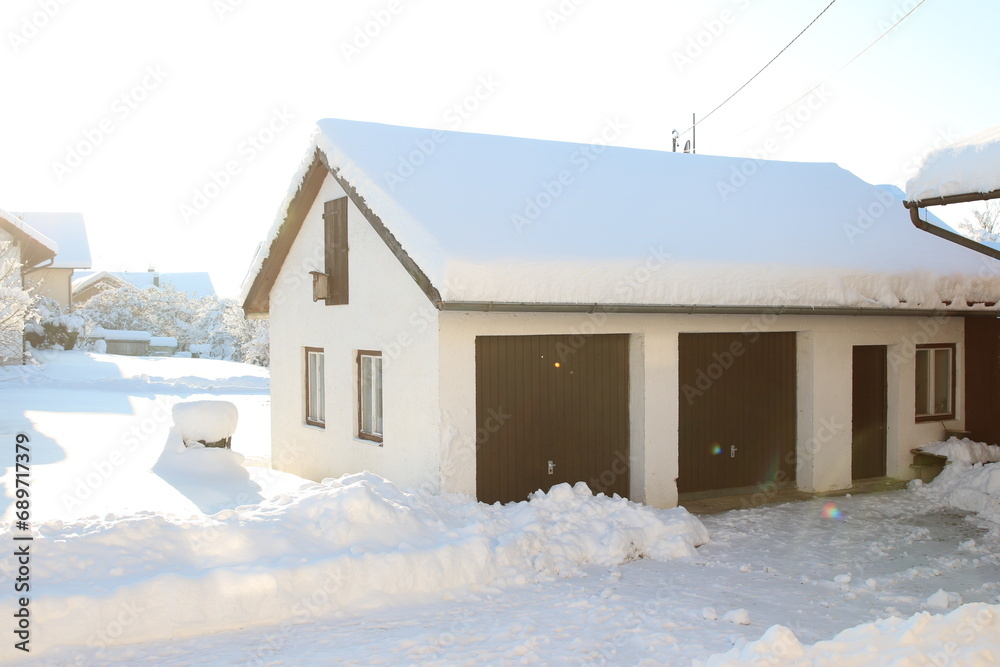 Eine Garage mit Schnee bedeckt im Sonnenlicht, Winter Wunderland Bayern