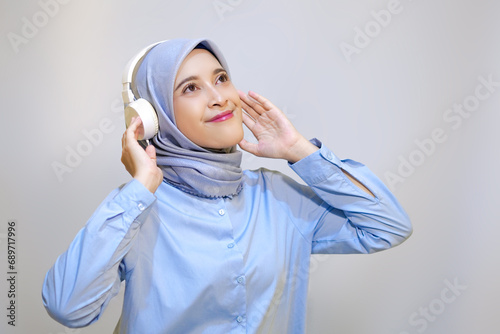 Cute young muslim woman enjoying music with headphone on. Enjoying music concept photo