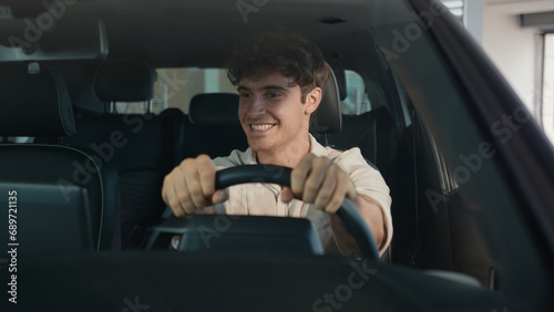 Caucasian happy carefree cheerful man buyer owner of new car guy successful businessman sitting inside automobile celebrate auto transport vehicle buying purchase dancing enjoy music at radio achieve