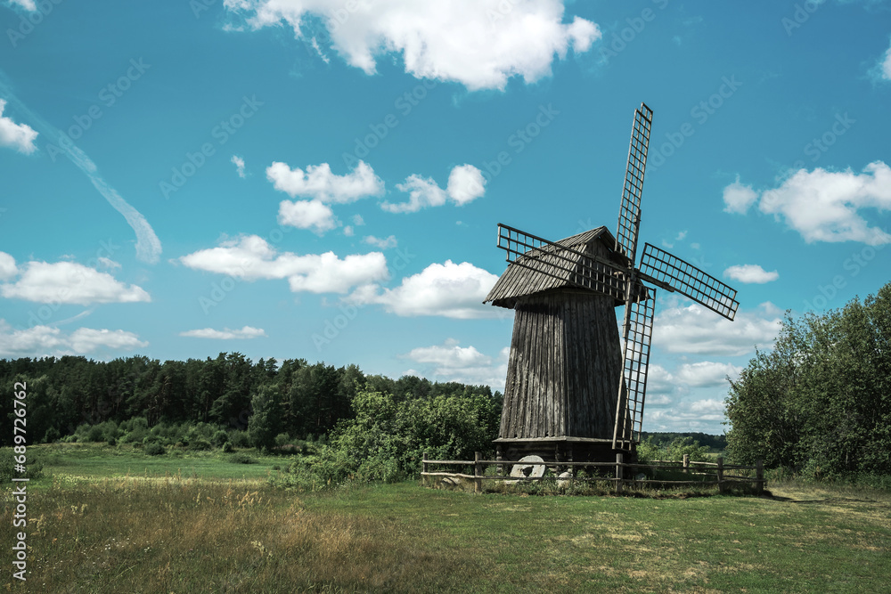 Fototapeta premium Landscape with an old wooden windmill.