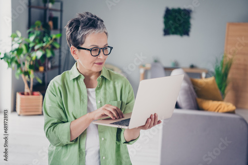 Photo of data researcher working woman wearing green shirt using laptop indoors freelancer during online conference isolated at home remote