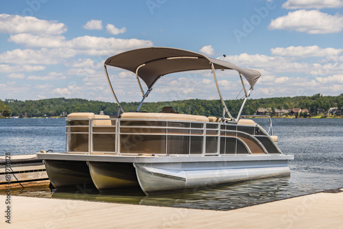 Pontoon boat at private marina dock on freshwater lake. photo