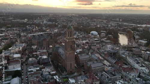 Peperbus tower of the The Roman Catholic Onze Lieve Vrouwe ten Hemelopneming-basilica church in Zwolle rising up over the snowy rooftops during winter. photo