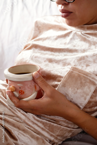 Cropped woman drinking tea. Cozy winter time background.