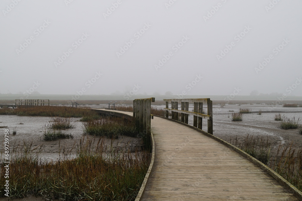 Wooden bridge in the sea - A foggy day at the North Sea