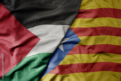 big waving national colorful flag of catalonia and national flag of palestine .