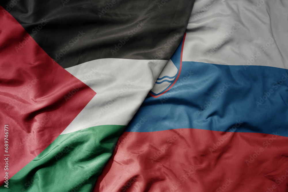 big waving national colorful flag of slovenia and national flag of palestine .