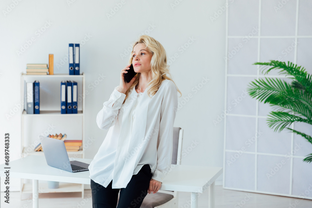 Businesswoman in office talking on smartphone small business online