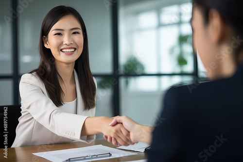 Fototapeta Naklejka Na Ścianę i Meble -  Happy business woman manager handshaking at office meeting. Smiling female hr hiring recruit at job interview, bank or insurance agent, lawyer making contract deal with client at work.