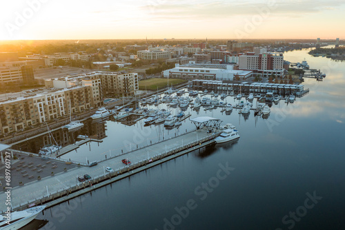 Aerial view of a marina on the Cape Fear River with Wilmington, North Carolina on the left during sunrise.