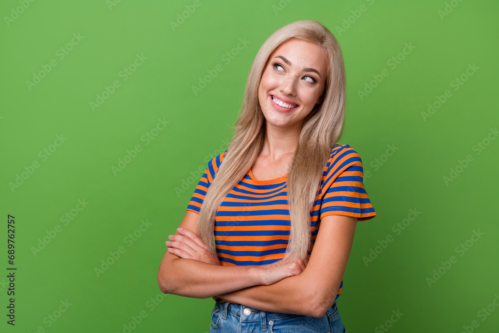 Portrait photo of dreaming blonde lady wear striped t shirt crossed hands look empty space clear idea isolated on green color background Portrait photo of dreaming blonde lady wear striped t shirt crossed hands look empty space clear idea isolated on green color background