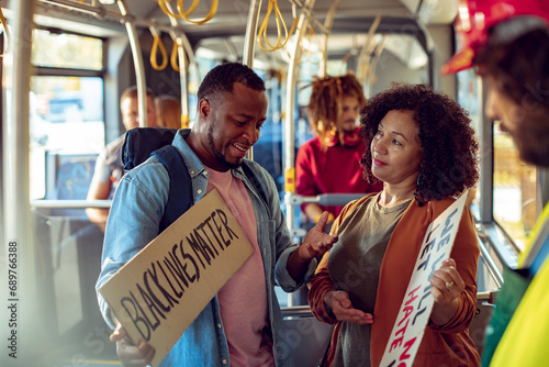 Young man and woman with anti racism signs on the bus photo