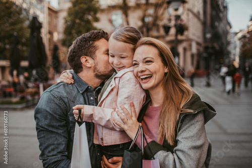 Happy young family with shopping bags downtown photo