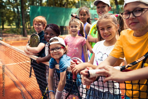 Portrait of diverse children on tennis clay court photo