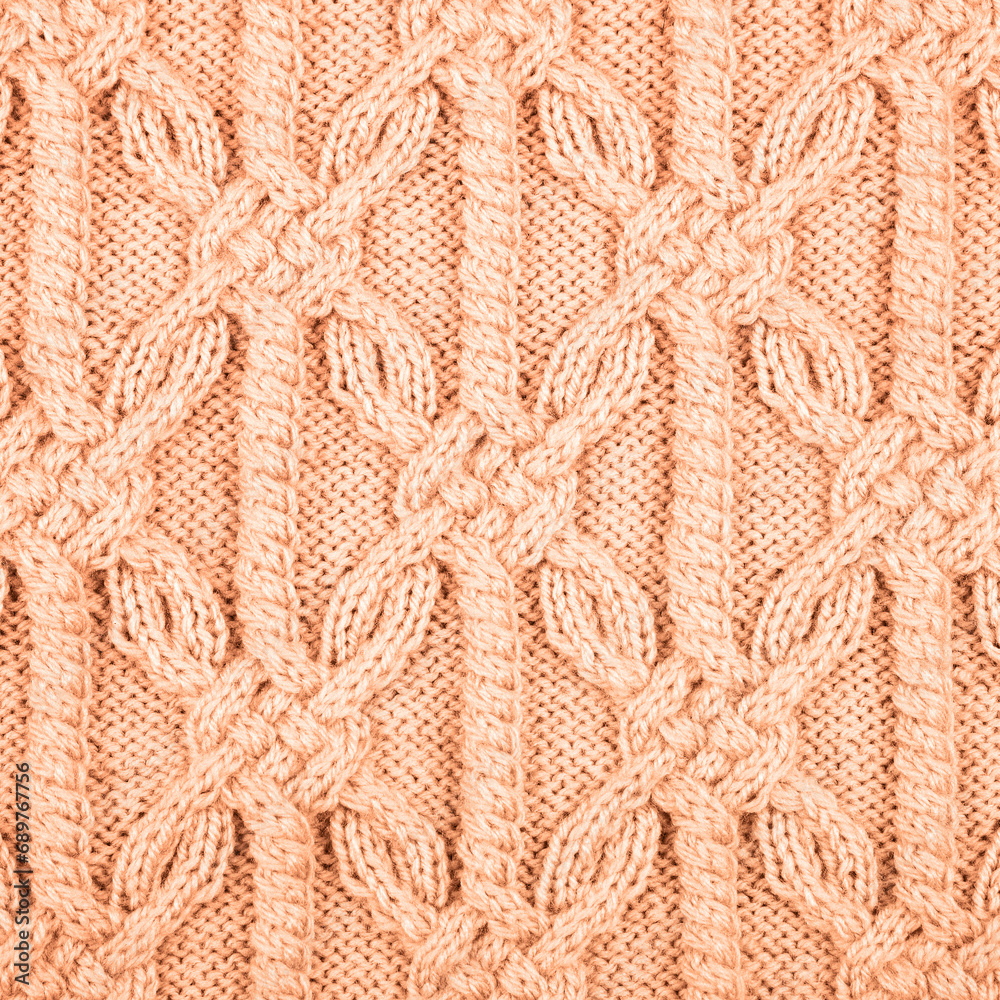 Knitted peach background. Large knitted fabric with a pattern. Close-up of a knitted blanket. Demonstrating the colors of 2024 - Peach Fuzz. Knitted peach background. Large knitted fabric with a pattern. Close-up of a knitted blanket. Demonstrating the colors of 2024 - Peach Fuzz.