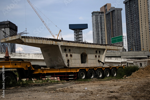 Construction site, bridge construction. The structures of the new bridge are built and installed on supports. View of the bridge construction site. bridge parts loaded onto a truck