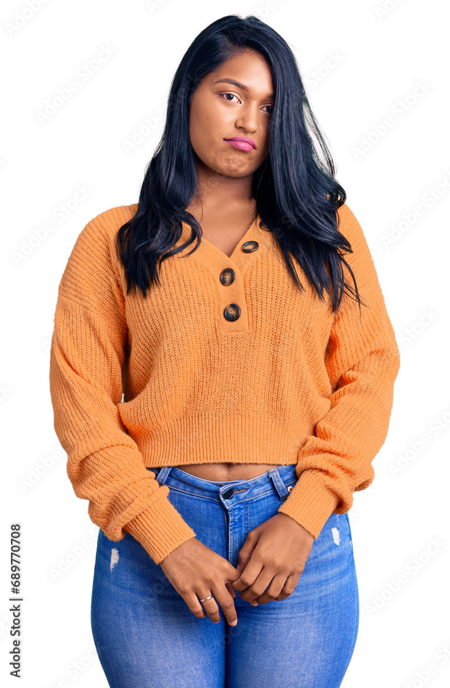 Hispanic woman with long hair wearing casual winter sweater depressed and worry for distress, crying angry and afraid. sad expression. Hispanic woman with long hair wearing casual winter sweater depressed and worry for distress, crying angry and afraid. sad expression.