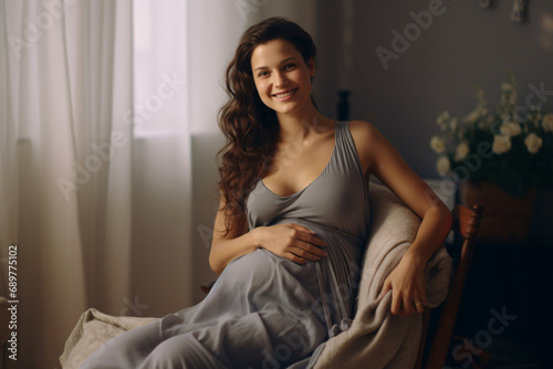 Portrait of a pregnant woman holding her belly and smiling