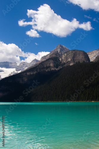 A deep blue mountain lake surrounded by forest  © Esther