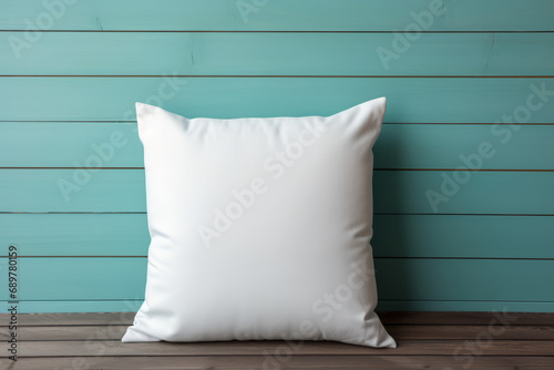 White square cushion mock-up on wood surface against turquoise wall, one blank empty throw pillow with minimalism background template.