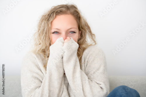 woman freezing sitting on sofa having symptoms coughing at home, flu concept