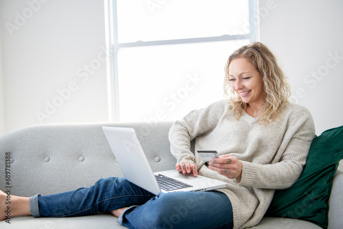 woman shopping from home. Girl enter credit card info on webside to make purchase photo