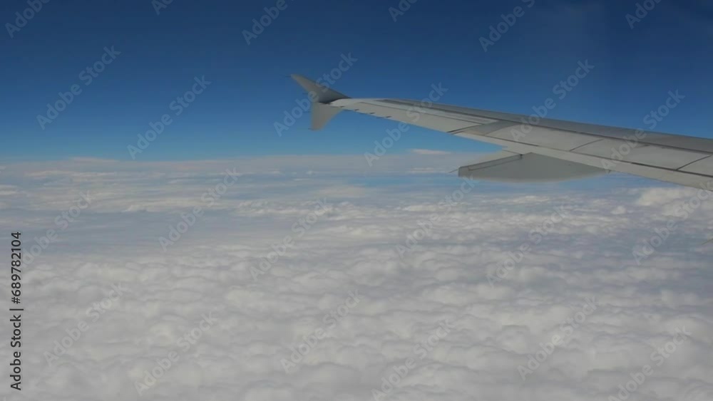 Video recorded in slow motion from the window of an airplane, showing a trip, you can see the clouds, the sky, the plane's wing and the sunset. Video recorded in slow motion from the window of an airplane, showing a trip, you can see the clouds, the sky, the plane's wing and the sunset.