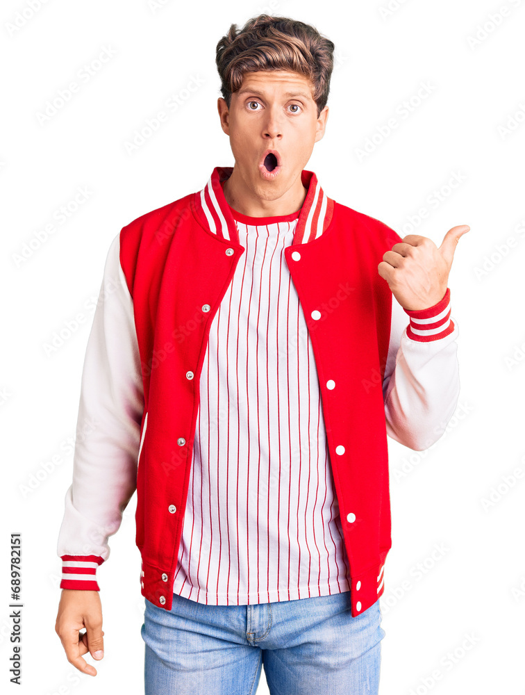Young handsome man wearing baseball uniform surprised pointing with hand finger to the side, open mouth amazed expression. Young handsome man wearing baseball uniform surprised pointing with hand finger to the side, open mouth amazed expression.