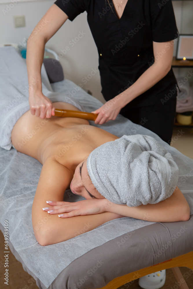 Young woman getting a back massage in a spa salon. Beauty treatment concept.