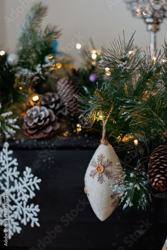 Christmas background with pine branch and beautiful yellow shiny bokeh. Wool pine cone. White snowflake. Shallow depth of field