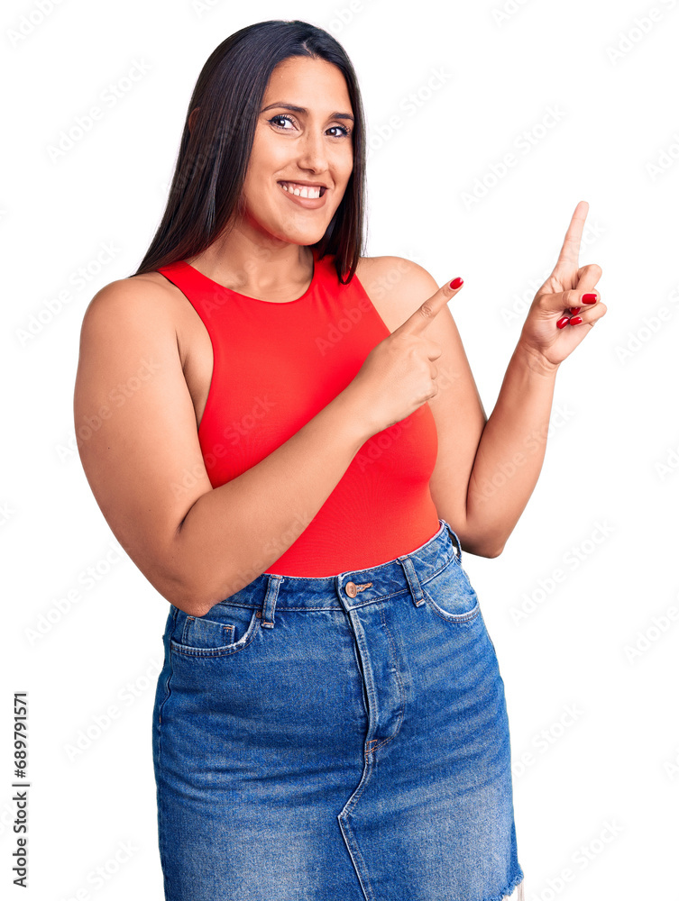 Young beautiful brunette woman wearing casual sleevelss t-shirt smiling and looking at the camera pointing with two hands and fingers to the side. Young beautiful brunette woman wearing casual sleevelss t-shirt smiling and looking at the camera pointing with two hands and fingers to the side.