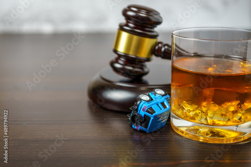 Judge's mace on a table in a court of law, glass of whiskey and miniature car. No drinking while driving concept photo
