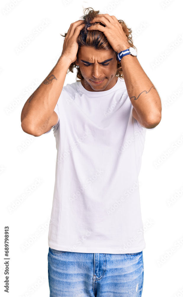 Young hispanic man wearing casual white tshirt suffering from headache desperate and stressed because pain and migraine. hands on head. Young hispanic man wearing casual white tshirt suffering from headache desperate and stressed because pain and migraine. hands on head.