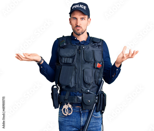 Young handsome man wearing police uniform clueless and confused with open arms, no idea concept.