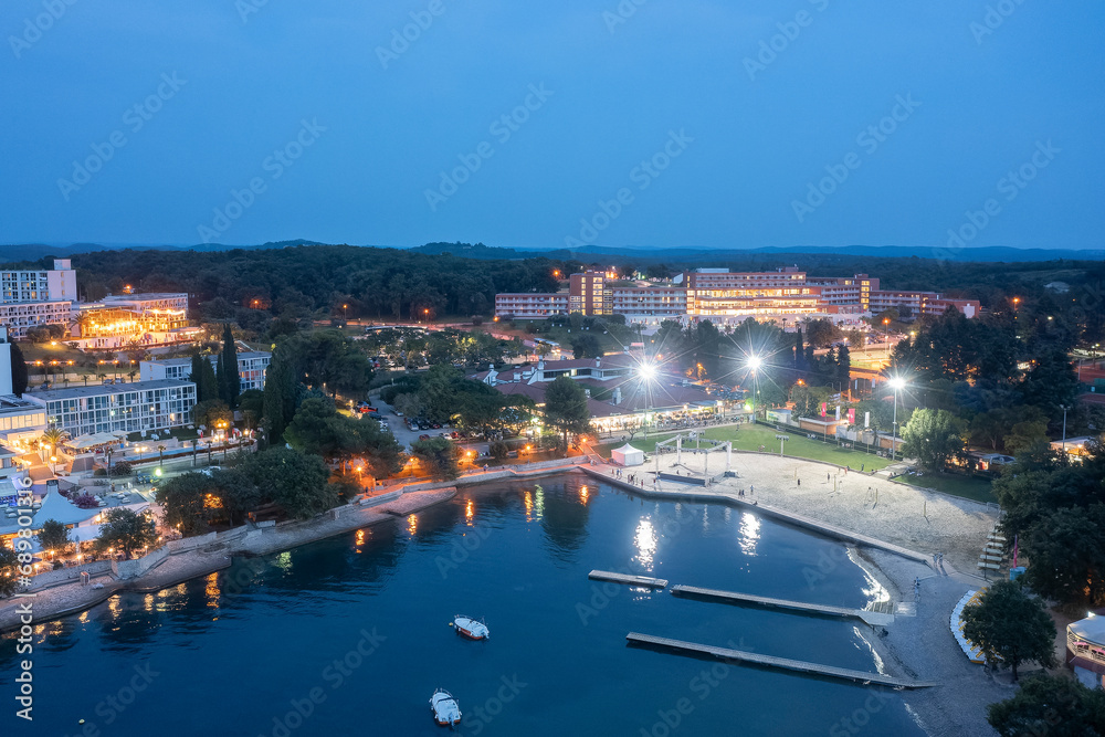 A seaside resort on the Adriatic coast at night in an electric glow. Night photography from a drone.