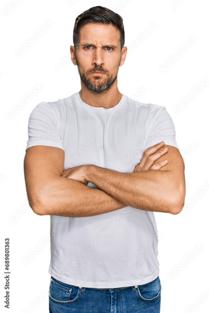 Handsome man with beard wearing casual white t shirt skeptic and nervous, disapproving expression on face with crossed arms. negative person. Handsome man with beard wearing casual white t shirt skeptic and nervous, disapproving expression on face with crossed arms. negative person.