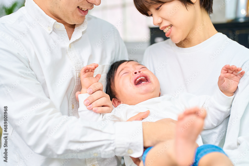 Obraz premium 泣く赤ちゃんと抱きかかえる両親