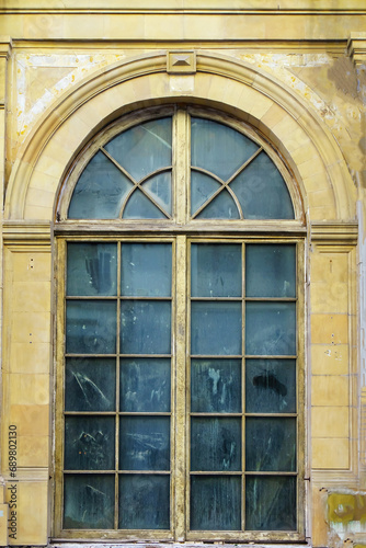 Large old window with arched top and dirty glass