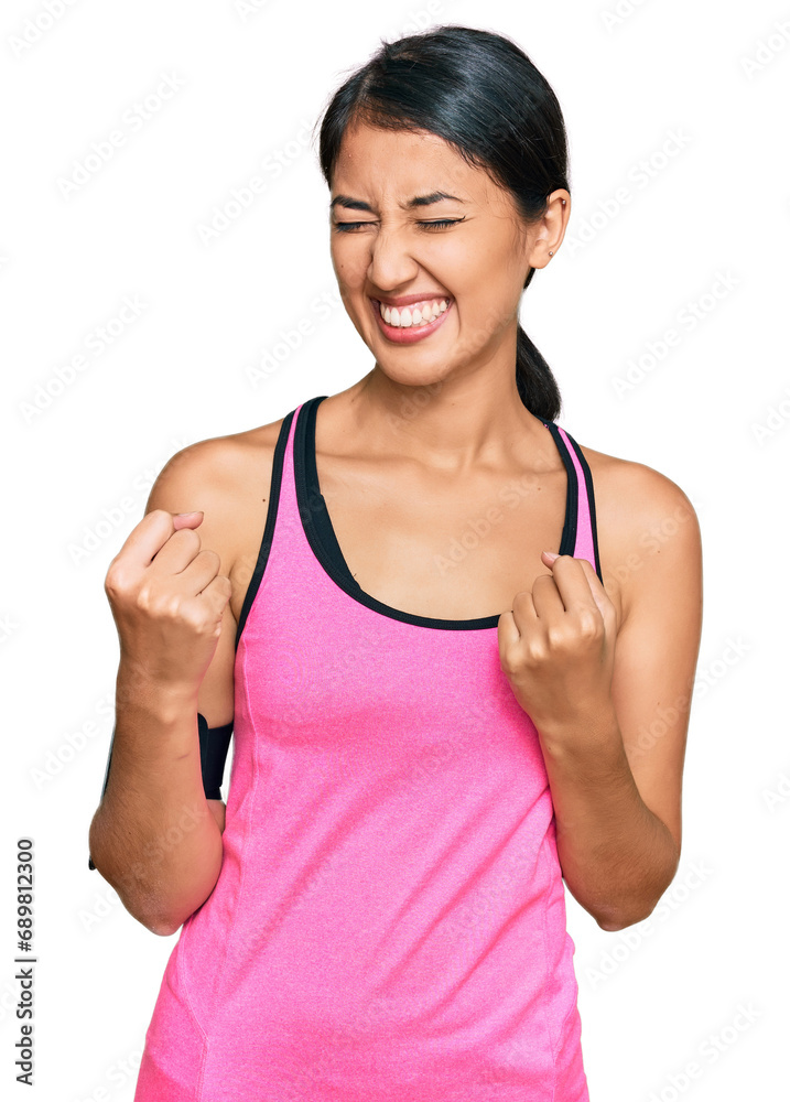 Beautiful asian young sport woman wearing sportswear and arm band very happy and excited doing winner gesture with arms raised, smiling and screaming for success. celebration concept. Beautiful asian young sport woman wearing sportswear and arm band very happy and excited doing winner gesture with arms raised, smiling and screaming for success. celebration concept.