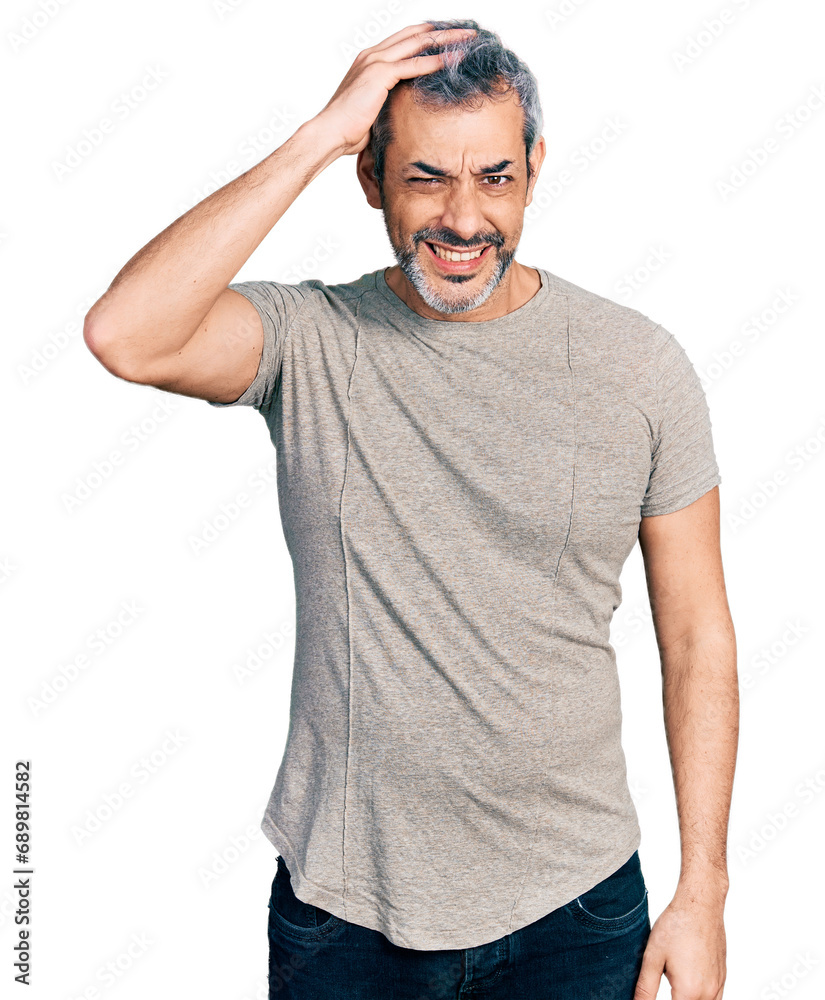 Middle age hispanic with grey hair wearing casual grey t shirt confuse and wonder about question. uncertain with doubt, thinking with hand on head. pensive concept.