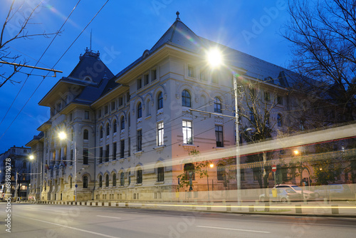 Bucharest town hall building exterior with car trail at twilight. Administration landmark in Romania capital city.