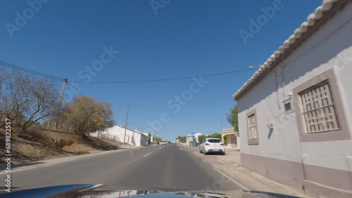 First person view, FPV, from dashcam of car driving along the Algarve Coast in Portugal towards Albufeira, driving on the highway. Road trip video in POV, with blue sky photo