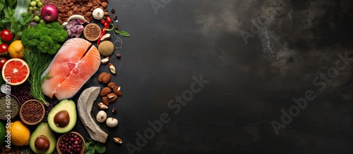 Balanced diet food background Organic food for healthy nutrition superfoods Meat fish legumes nuts seeds greens oil and vegetables Top view on dark stone table. Copyspace image. Square banner photo