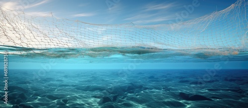 A small trawl net with biological samples is lifted from the sea. Copyspace image. Square banner. Header for website template © vxnaghiyev