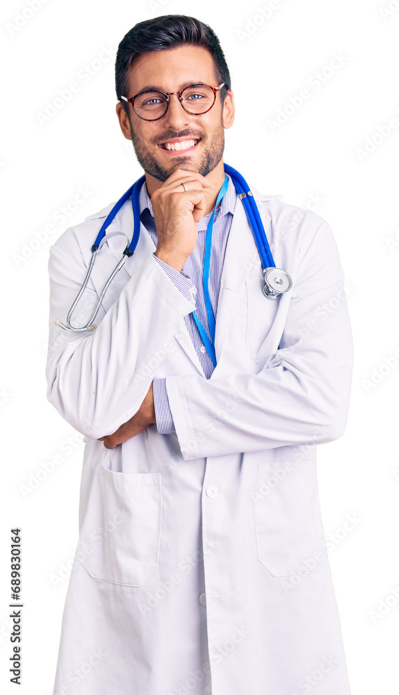 Young hispanic man wearing doctor uniform and stethoscope looking confident at the camera smiling with crossed arms and hand raised on chin. thinking positive. Young hispanic man wearing doctor uniform and stethoscope looking confident at the camera smiling with crossed arms and hand raised on chin. thinking positive.