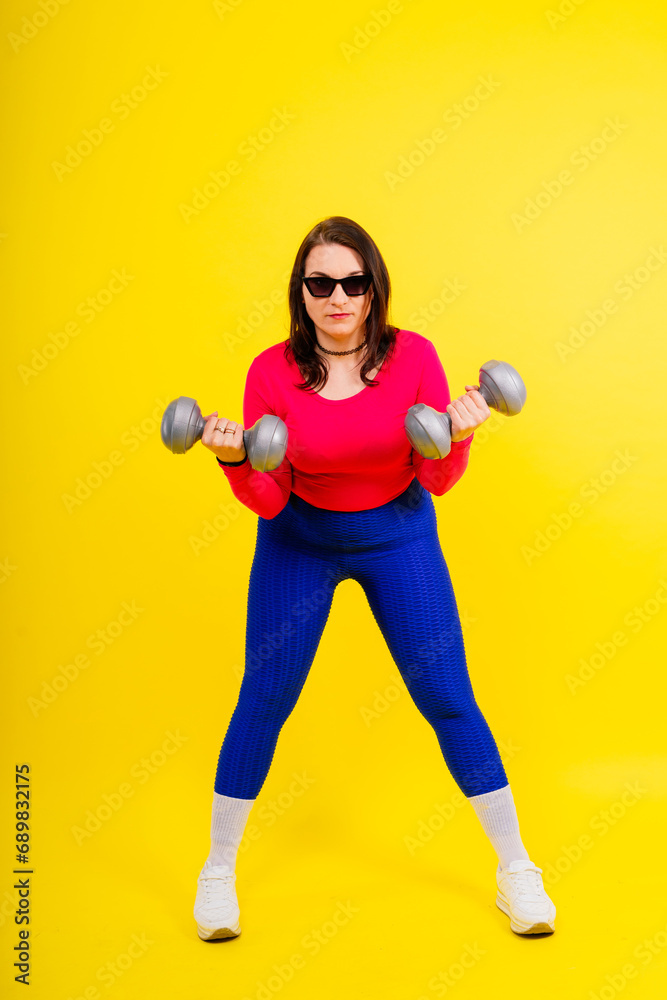 Young smiling happy chubby overweight plus size big fat fit woman warm up training hold dumbbells Young smiling happy chubby overweight plus size big fat fit woman warm up training hold dumbbells